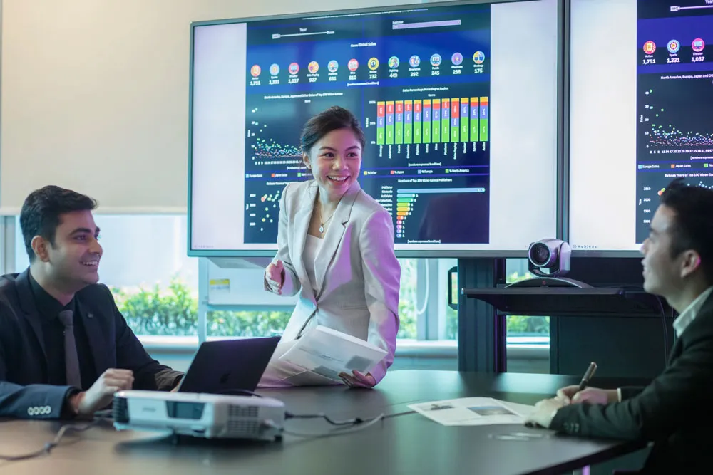 A woman is leading a meeting with 2 men